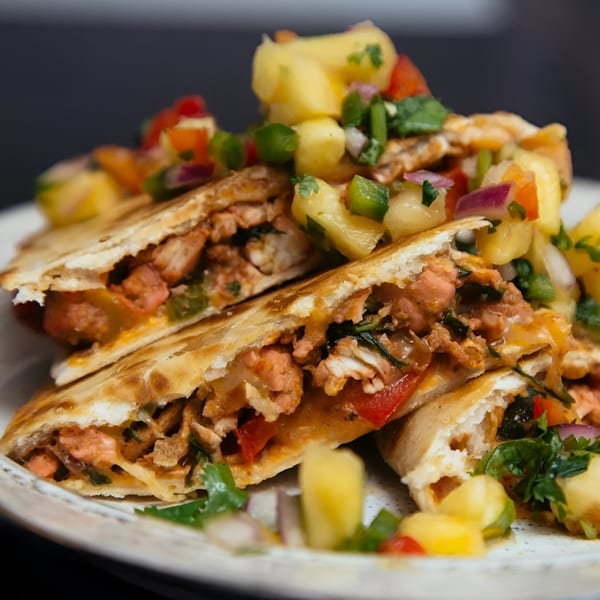 Tikka Curry & Grill quesadillas filled with meat and vegetables, topped with pineapple salsa.