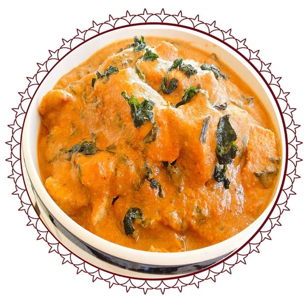 Tikka Curry & Grill's chicken tikka masala, a rich orange curry with chicken pieces and green herbs.
